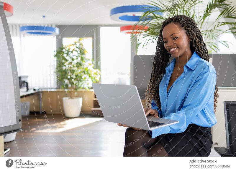 Glückliche junge schwarze Geschäftsfrau mit Laptop im Büro benutzend Arbeit Lächeln Internet Unternehmer schön Business Frau Afro-Look formal Arbeitsplatz