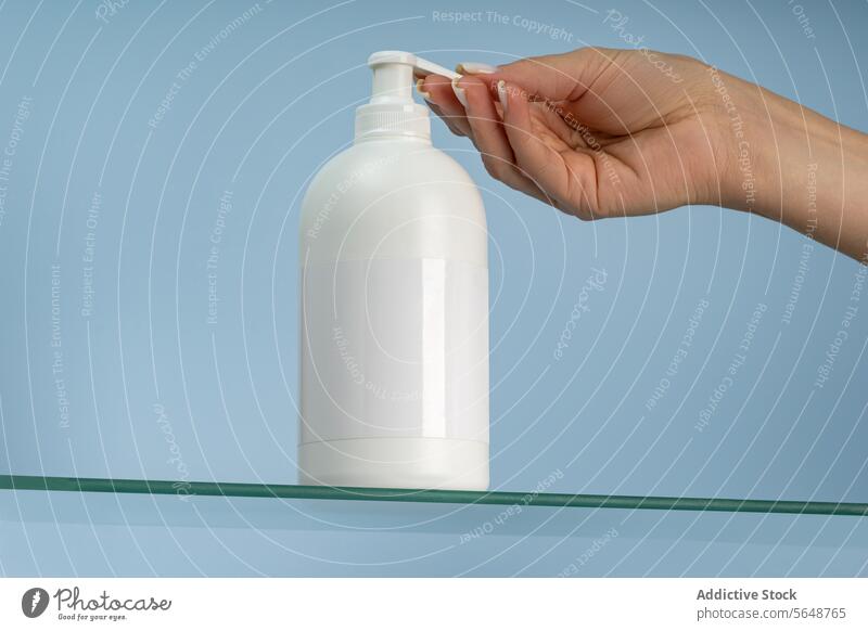 Handspender für Lotion aus einer weißen Pumpflasche Pumpe Flasche Blauer Hintergrund Hautpflege Feuchtigkeitscreme Körperpflege Spender Kosmetik Behandlung