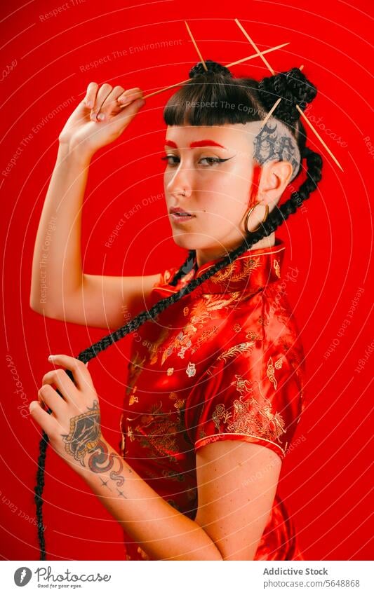 Frau in traditioneller asiatischer Tracht posiert auf rotem Hintergrund Kleid Pose Selbstvertrauen Mode Kultur Kleidung Design jung kompliziert Stil pulsierend