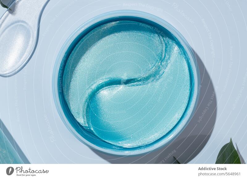 Draufsicht auf ein Hautpflegegel in einem eleganten Glastiegel Gel Glasgefäß blau Kosmetik Schönheit Eleganz schimmern Produkt Container Hautpflegeprodukt