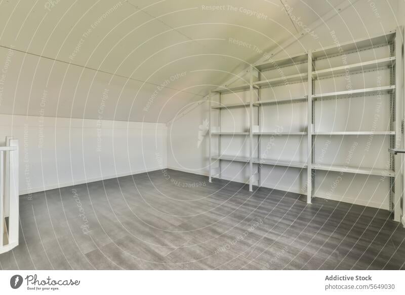 Leerer Dachboden mit Metallregalen Raum leer Lager Regal weiß Wand grau Stock Innenbereich Sauberkeit übersichtlich Speicherlösung häusliche Lagerung Haushalt