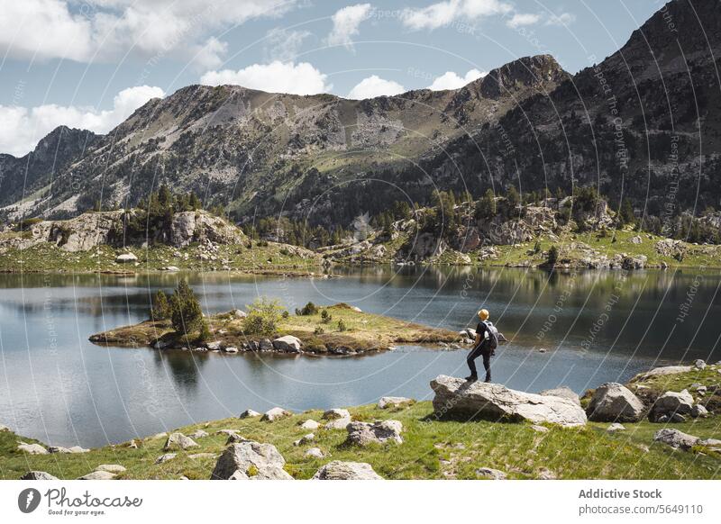 Mann steht in der Nähe eines ruhigen Sees in den Bergen im Urlaub Wanderer Tourist Berge u. Gebirge Nationalpark Abenteuer Landschaft Reflexion & Spiegelung