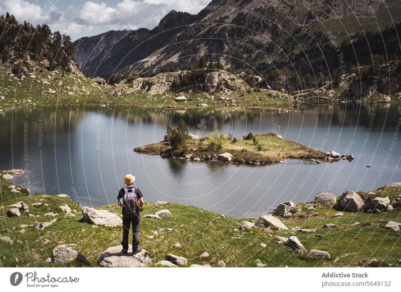 Mann steht in der Nähe eines ruhigen Sees in den Bergen im Urlaub Wanderer Tourist Berge u. Gebirge Nationalpark Abenteuer Landschaft Reflexion & Spiegelung