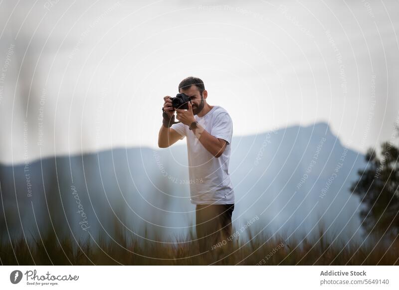 Mann fängt die Natur im Nationalpark auf einer Wiese ein Tourist Fotokamera fotografieren Fotograf Freizeit Urlaub benutzend Erholung Fotografie Reisender