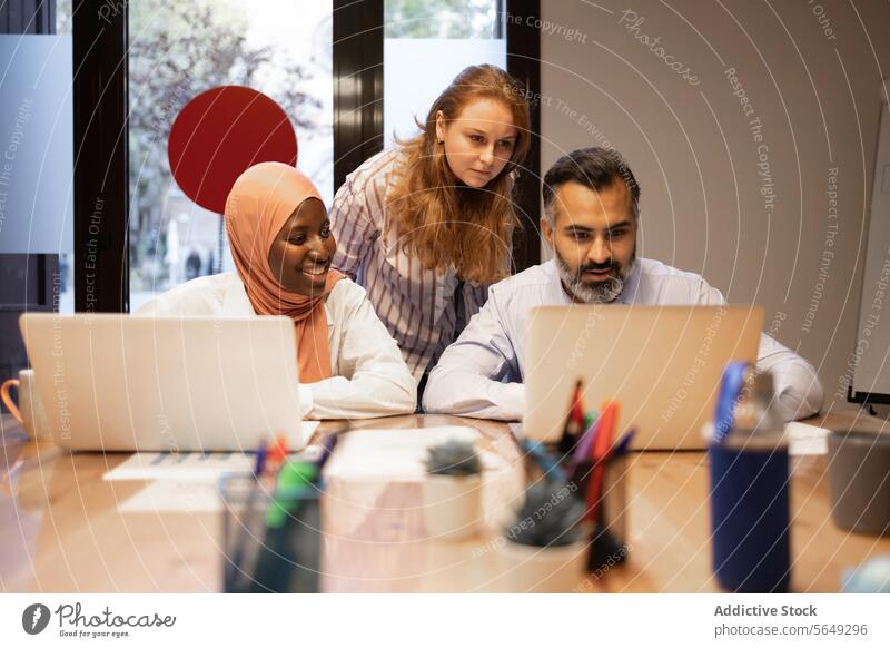 Verschiedene Kollegen arbeiten mit Laptops in einem modernen Büro während einer Geschäftsbesprechung Lächeln Netbook pc Browsen Mitarbeiterin Projekt