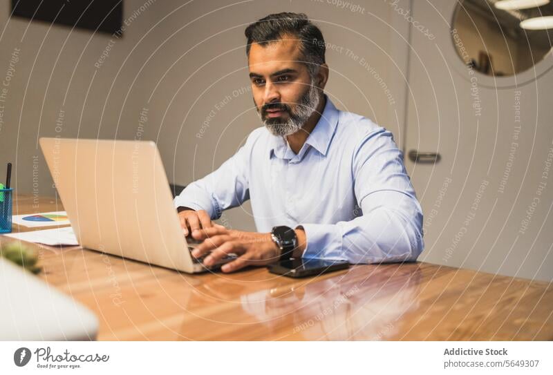 Konzentrierter Geschäftsmann, der mit seinem Laptop an einem neuen Projekt in einem modernen Büro arbeitet Mann benutzend Manager Arbeit Fokus Business ernst pc