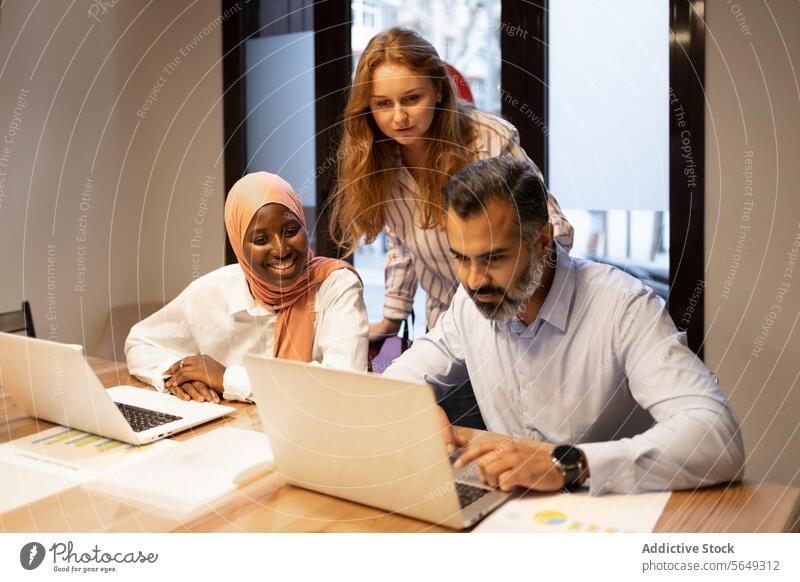 Verschiedene Kollegen arbeiten mit Laptops in einem modernen Büro während einer Geschäftsbesprechung Lächeln Netbook pc Browsen Mitarbeiterin Projekt
