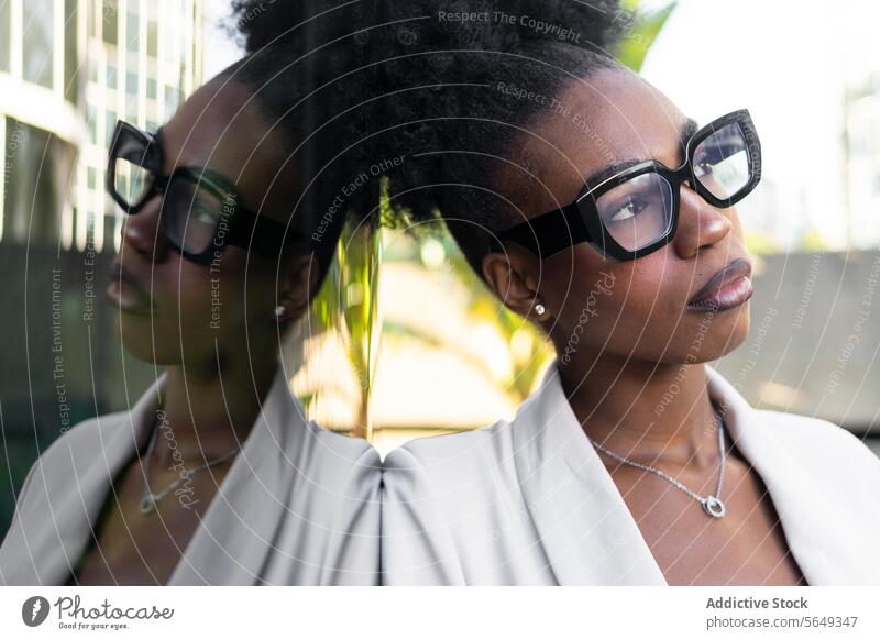 Nachdenkliche schwarze Managerin mit Brille, die sich an eine Glaswand lehnt Geschäftsfrau nachdenken Wand Reflexion & Spiegelung schön Lehnen besinnlich
