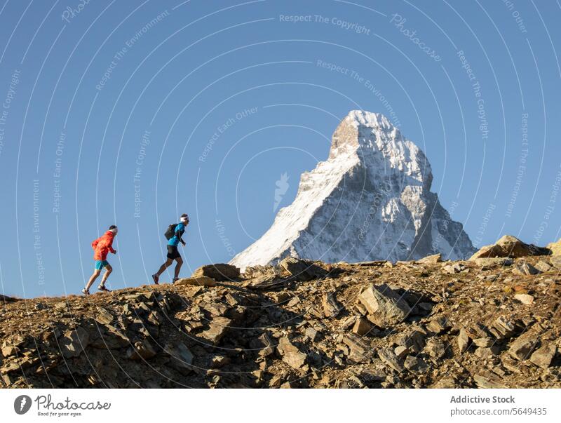 Wanderer in farbenfroher Tracht bei der Überquerung des Matterhorns Nachlauf felsig schneebedeckt Berge u. Gebirge übersichtlich Himmel im Freien Aktivität