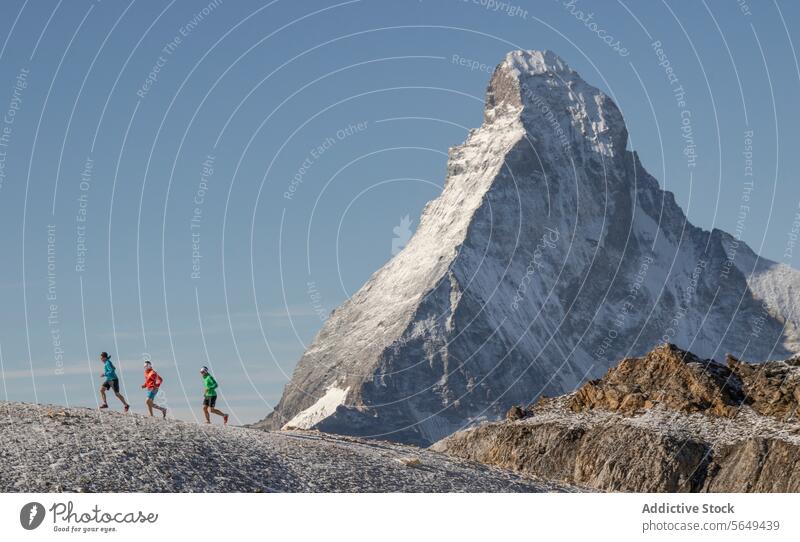 Seitenansicht von drei Athleten beim Laufen auf der Strecke am Matterhorn Sportbekleidung rennen Berge u. Gebirge Nachlauf Schnee Hintergrund übersichtlich
