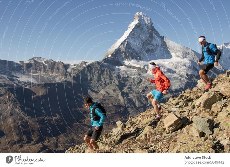 Drei Menschen rennen einen Berg hinunter Athlet Nachlauf robust Berge u. Gebirge Weg Matterhorn Gipfel übersichtlich Himmel im Freien Sport Fitness Abenteuer