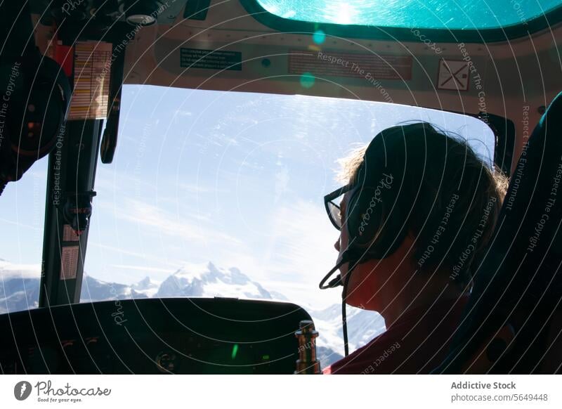 Anonym von Passagier, der aus einem Hubschrauber herausschaut Blick auf den Berggipfel Kopfhörer Ansicht Berge u. Gebirge Gipfel Schnee blau Himmel Antenne