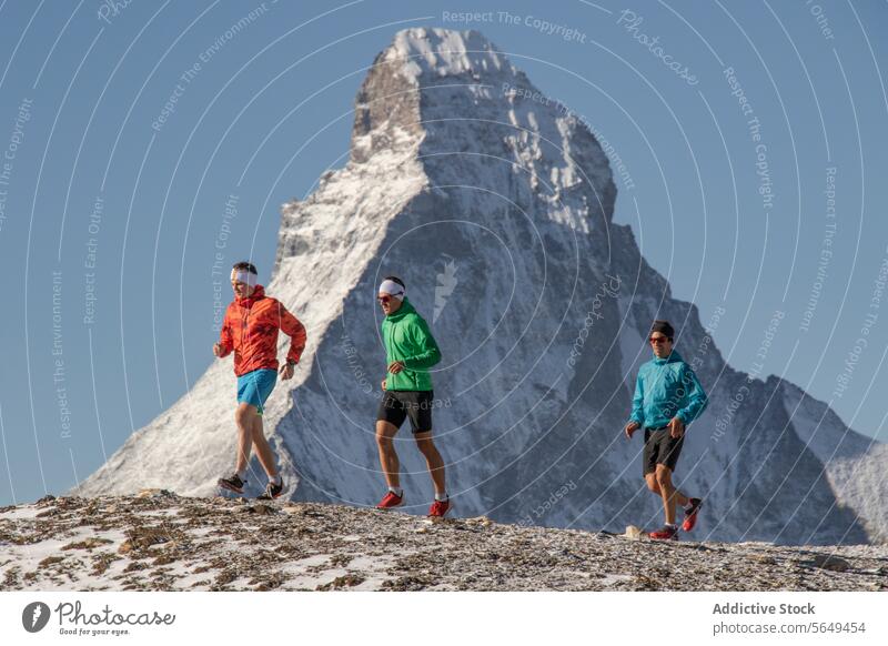 Seitenansicht von drei Athleten beim Laufen auf der Strecke am Matterhorn Sportbekleidung rennen Berge u. Gebirge Nachlauf Schnee Hintergrund übersichtlich
