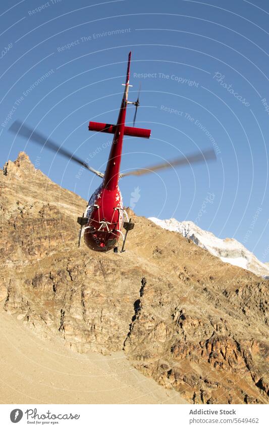 Landung eines Berghubschraubers Hubschrauber Berge u. Gebirge Landen Kamm robust rot Schnee Spitzenwerte blau Himmel übersichtlich Höhe Verkehr Antenne Flug