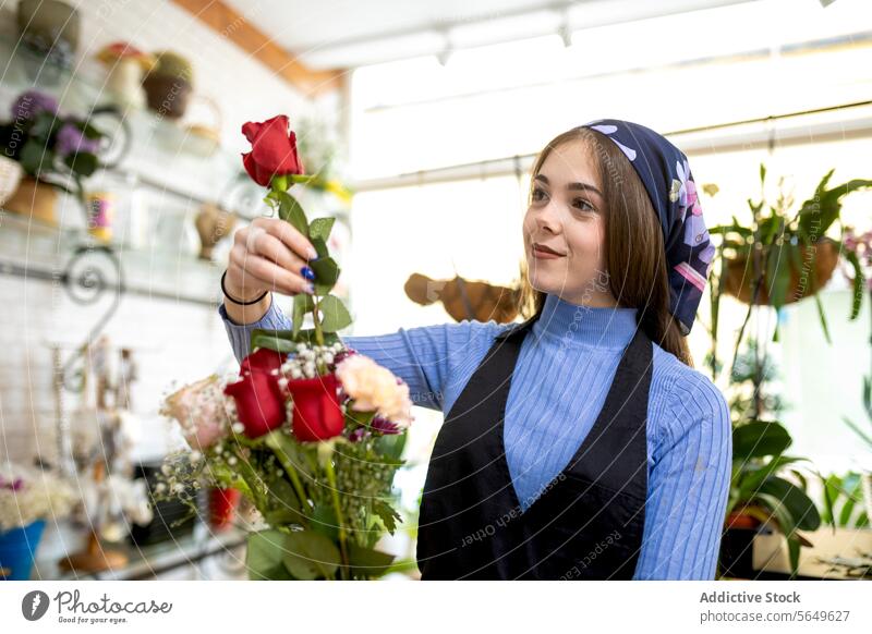 Glückliche Floristin macht Blumenstrauß Frau Blumenhändler einrichten Roséwein kreieren Laden Arbeit Werkstatt Lächeln jung Schürze Kopftuch Botanik Verkäuferin
