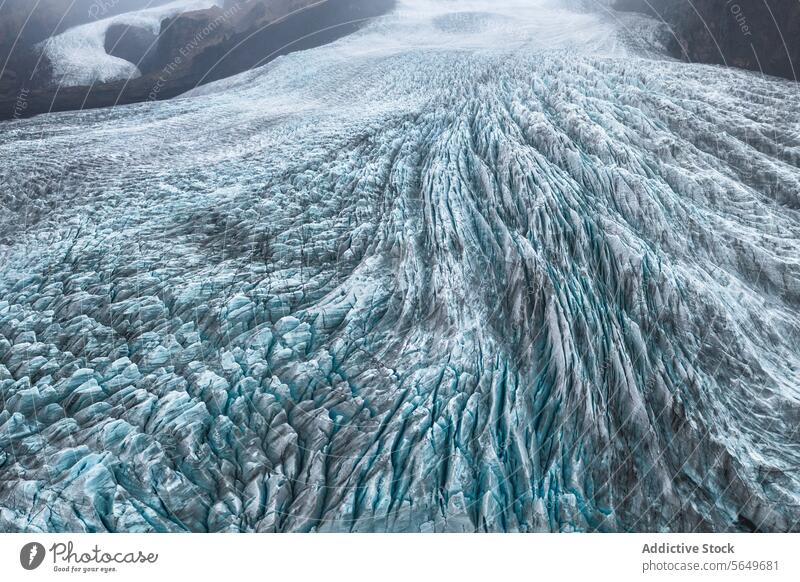 Ein atemberaubender Blick auf die verschlungenen Eisspalten und das zerklüftete Terrain des Vatnajokull-Gletschers vor der Kulisse der Berge Island Crevasse