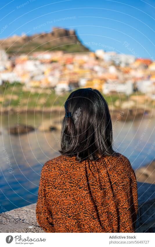 Frau bewundert Stadt und Meer im Urlaub Tourist Castelsardo MEER Ufer Blauer Himmel sonnig Rückansicht anonym Freizeitkleidung Blick erkunden reisen Lifestyle