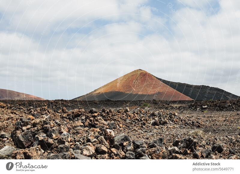 Vulkankegel auf Lanzarote bei bewölktem Himmel vulkanisch Zapfen Lava Felsen Landschaft robust wolkig Natur im Freien malerisch unfruchtbar Gelände Geologie