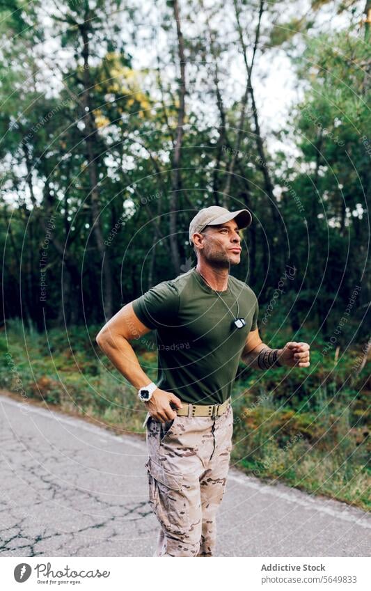 Selbstbewusstes reifes männliches Kommando beim Laufen in der Natur während des Trainings im Wald Mann Soldat Militär Joggen Fitness Straße Baum Routine