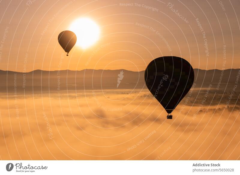 Heißluftballon schwebt im goldenen Sonnenaufgangshimmel über einer nebelverhangenen Landschaft Ballone Nebel Mexiko Flug Teotihuacán im Freien Abenteuer Himmel