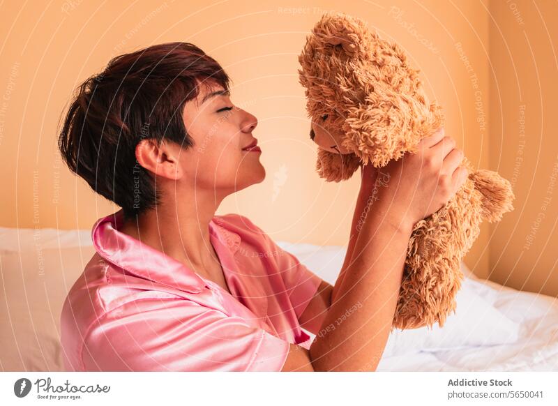 Junge Frau hält weichen Teddybär Bär Schlafzimmer Komfort Spielzeug Windstille Plüsch Angebot Appartement zu Hause friedlich Liebe Dame ruhig sitzen Vergnügen