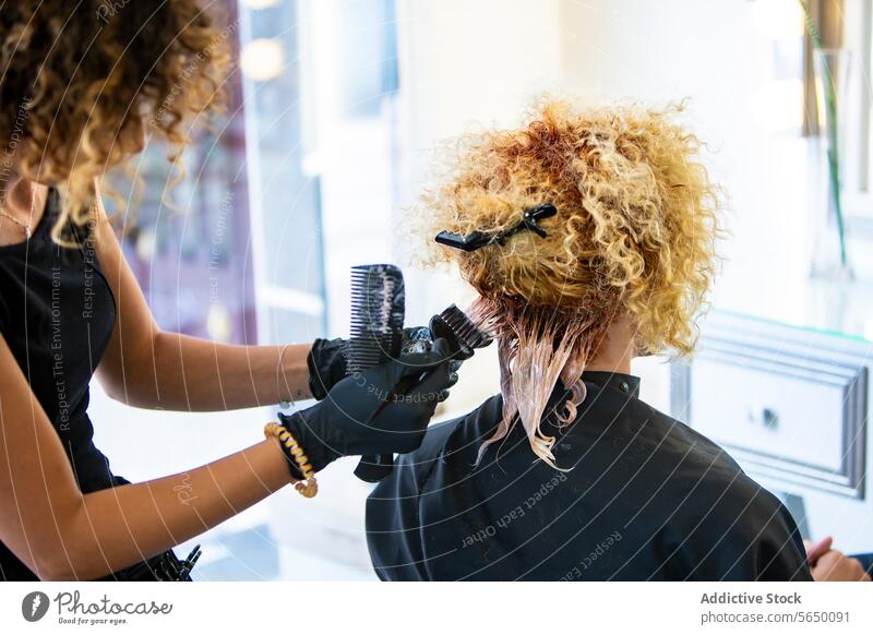Professionelle Stylistin bei der Arbeit an den Locken einer Kundin Salon Behaarung Schönheit Pflege Klient lockig professionell Stil Frau Friseur Haarschnitt
