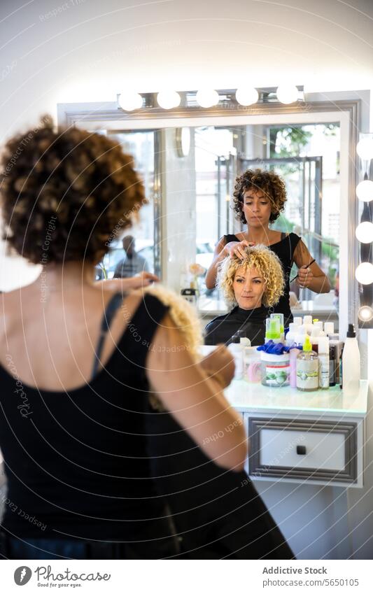 Friseurin formt die Locken einer Kundin im Salon Klient Spiegel Schönheit Produkt professionell Behaarung Formgebung Sitz Schönheitssalon Haarpflege Pflege Stil