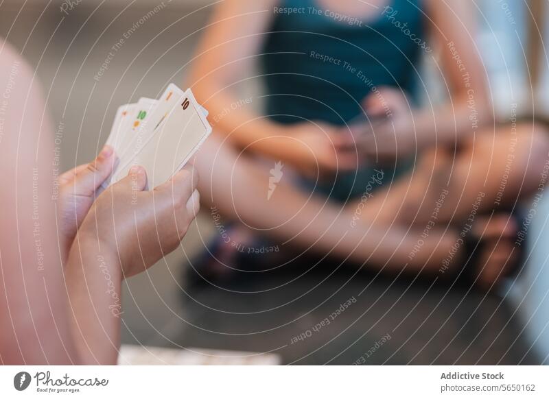 Anonyme Hand hält Spielkarten im Spiel Postkarte Spielen lässig Freund Halt Freizeit Aktivität spielen Menschengruppe Tischplatte Nummer Kartenspiel Fokus