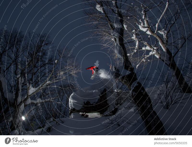 Person mit Snowboard beim Springen im verschneiten Wald Snowboarder springen sorgenfrei Snowboarding anonym Schnee Hügel Nackter Baum Urlaub Japan