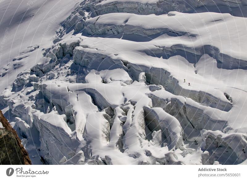 Luftaufnahme von anonymen Skifahrern in warmer Kleidung beim Überqueren eines schneebedeckten Gletschers in Zermatt, Schweiz Schnee Eis Kamm Nachlauf alpin