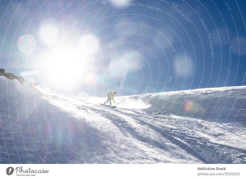 Low angle of Anonymous Mann Snowboarden auf Berg gegen Sonne und blauen Himmel in Zermatt Tourist Schnee Sport majestätisch Berge u. Gebirge Berghang Landschaft