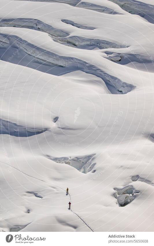 Luftaufnahme von anonymen Skifahrern in warmer Kleidung beim Überqueren eines schneebedeckten Gletschers in Zermatt, Schweiz Schnee Eis Kamm Nachlauf alpin