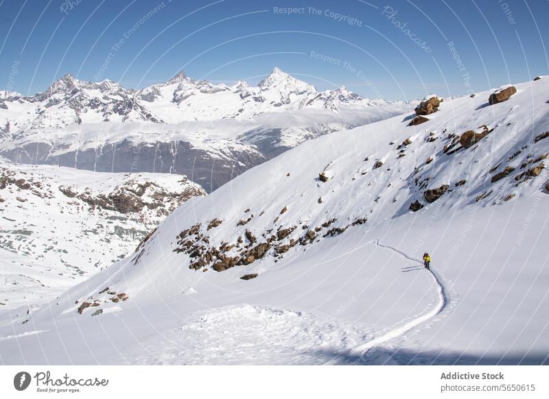 Hohe Winkel der unerkennbaren Touristen Skifahren auf schneebedeckten Berg in Zermatt unter blauem Himmel Schnee Berge u. Gebirge Skifahrer Landschaft