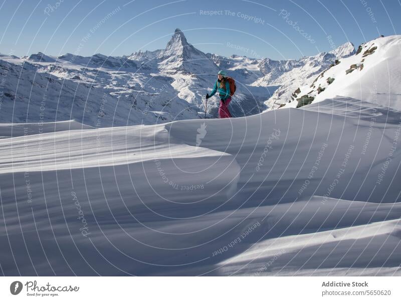 Seitenansicht einer anonymen Frau in warmer Kleidung beim Skifahren auf einem verschneiten Berg im Urlaub in Zermatt Tourist Spaziergang Rucksack Schnee
