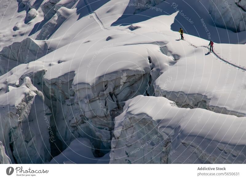 Von oben von anonymen Skifahrern in warmer Kleidung beim Überqueren eines schneebedeckten Gletschers in Zermatt, Schweiz Schnee Eis Kamm Nachlauf alpin Gelände