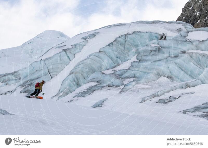 Seitenansicht eines Snowboarders beim Wandern in der Nähe von Gletscherformationen in Zermatt wandern Formationen Schnee Fläche Schweiz turmhoch Wände Eis