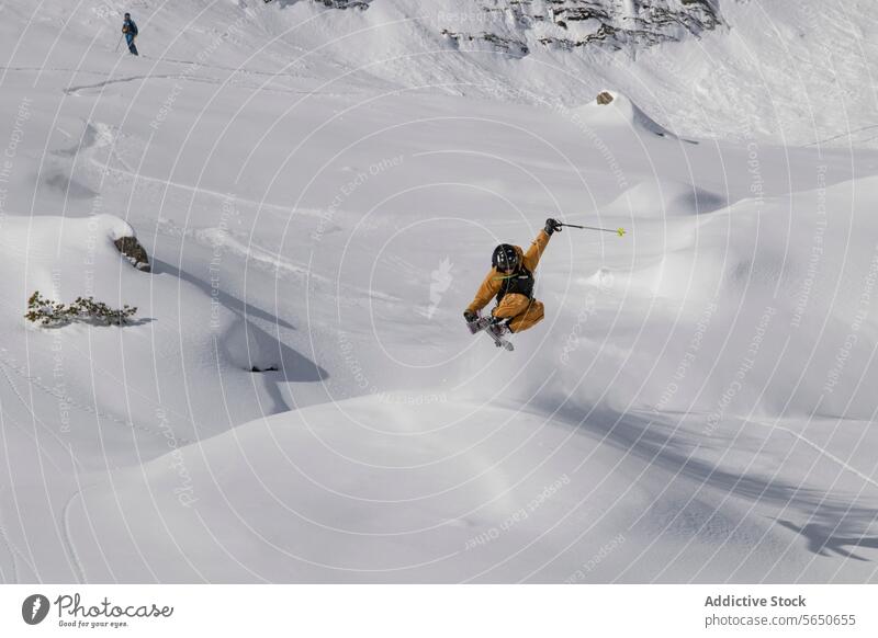 Anonymer Tourist im Anzug, der mit Skiern auf einem Berghang springt, während er in den Schweizer Alpen Urlaub macht Skifahrer Schnee Berge u. Gebirge Abenteuer