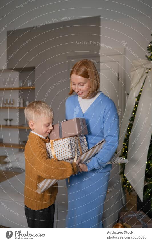 Fröhliche Mutter und Sohn teilen Weihnachtsgeschenke Weihnachten Geschenk präsentieren Teilen Freude Feiertag gemütlich Dekoration & Verzierung festlich Junge