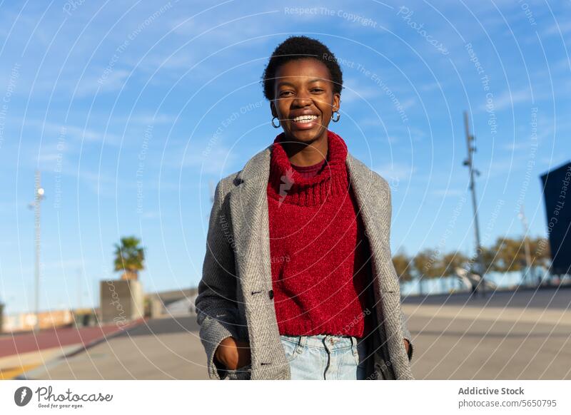 Fröhliche schwarze Frau beim Spaziergang in der Stadt Hand-in-Tasche schlendern Großstadt Wochenende Freizeit urban Sonnenlicht Lächeln heiter Glück Erwachsener