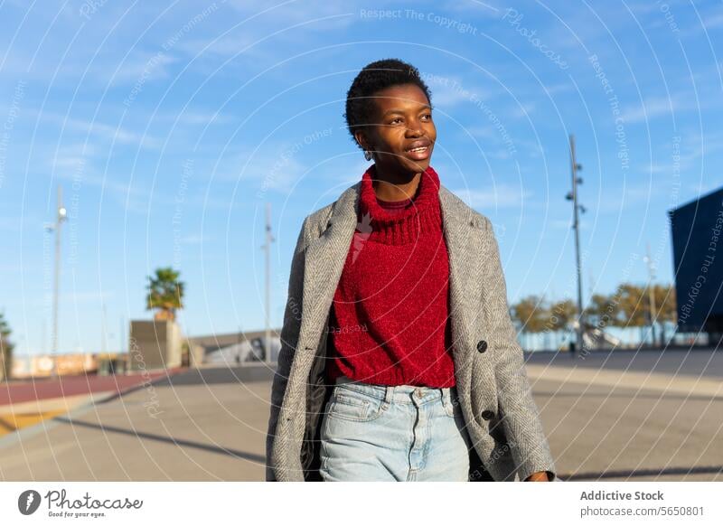 Glückliche schwarze Frau beim Spaziergang in der Stadt schlendern Großstadt Wochenende Freizeit urban Sonnenlicht Lächeln Erwachsener Afroamerikaner ethnisch