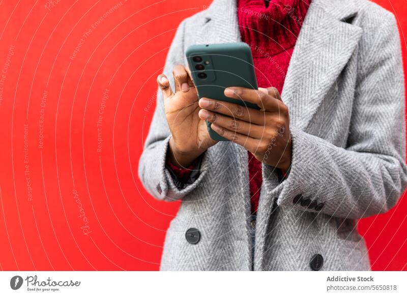 Anonyme schwarze Frau benutzt Mobiltelefon in der Nähe der Wand Smartphone Browsen Texten Surfen Funktelefon benutzend Kommunizieren Telefon Talkrunde Straße