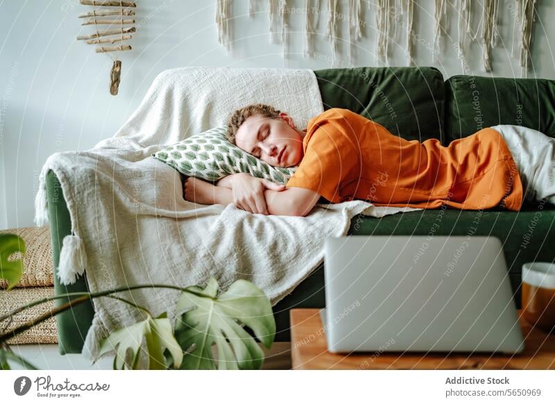 Junge Frau schläft auf bequemem Sofa mit Kissen zu Hause neben Laptop und Tasse schlafen Appartement Liege Komfort sich[Akk] entspannen schlafend Mittagsschlaf