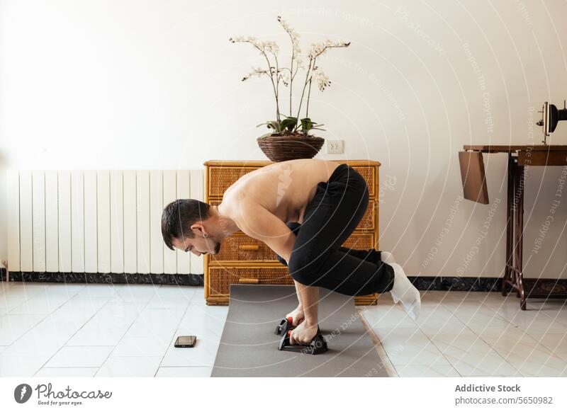 Konzentrierter junger Mann bei der Übung "Tuck Planche" mit Kurzhanteln üben Frosch stehen Sonnenaufgang Rehabilitation Training passen Wellness Wohlbefinden