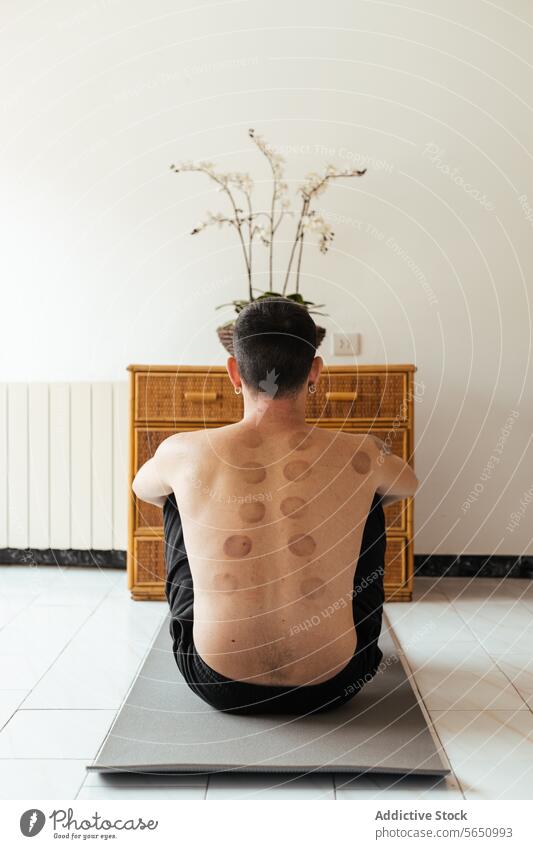 Anonymer Mann ohne Hemd auf Yogamatte sitzend Übung Unterlage Rehabilitation Mark Physiotherapie Rücken Wellness Pflege Therapie heimwärts üben Aktivität