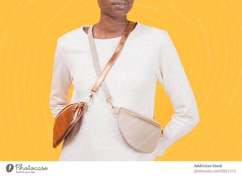 Anonyme modische schwarze Frau mit Umhängetasche isoliert auf gelbem Hintergrund Babytragetuch Tasche trendy Mode Accessoire Geldbörse Afroamerikaner Eleganz