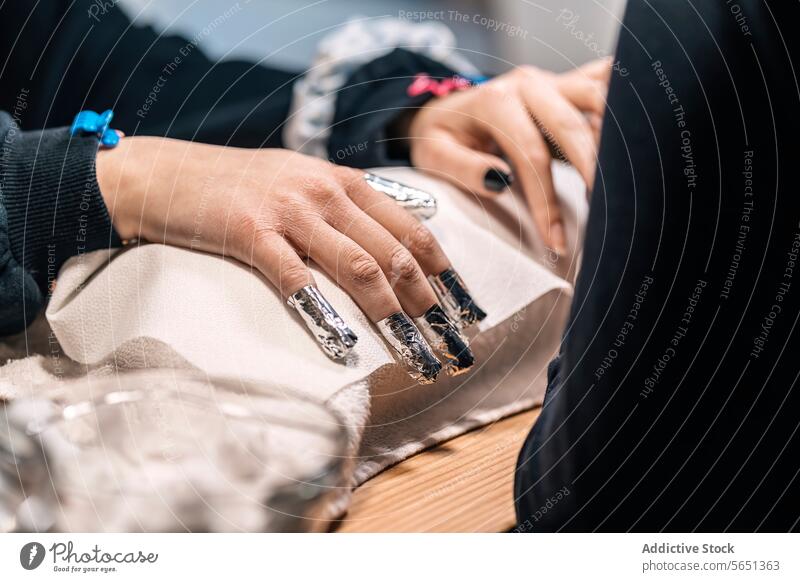 Crop gesichtslose Frauen mit Nagelkünstler und Entfernung Gel Nagellack mit Folie im Salon Maniküre nageln Schönheit polnisch Firnis Dienst Hand Spa Stil