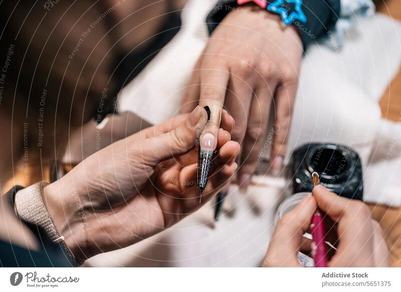 Maniküre-Meisterin zeichnet auf den Nagel einer Kundin im Studio Frauen Kosmetikerin Nagellack zeichnen Kunst Design Kunde nageln Verlängerung Bürste Salon