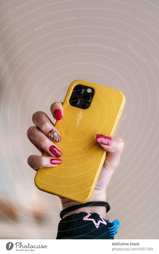 Crop Frau mit roter Nagelkunst hält Handy Smartphone Maniküre Nagellack nageln Kunst kreativ gelb Stil Gerät Apparatur modern Mobile Farbe Telefon Körperteil