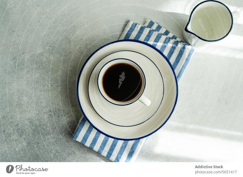 Frisch gebrühter Filterkaffee in einem minimalistischen Ambiente Kaffee Tropf gebraut Tasse Untertasse Serviette Streifen melken Kannen weiß Tischplatte Keramik