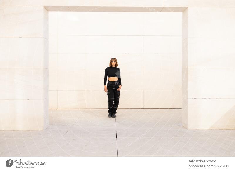 Modische Frau vor minimalistischem Hintergrund Mode Stil trendy Bekleidung posierend Selbstvertrauen geräumig Wand weiß lässig schick urban modern Einfachheit